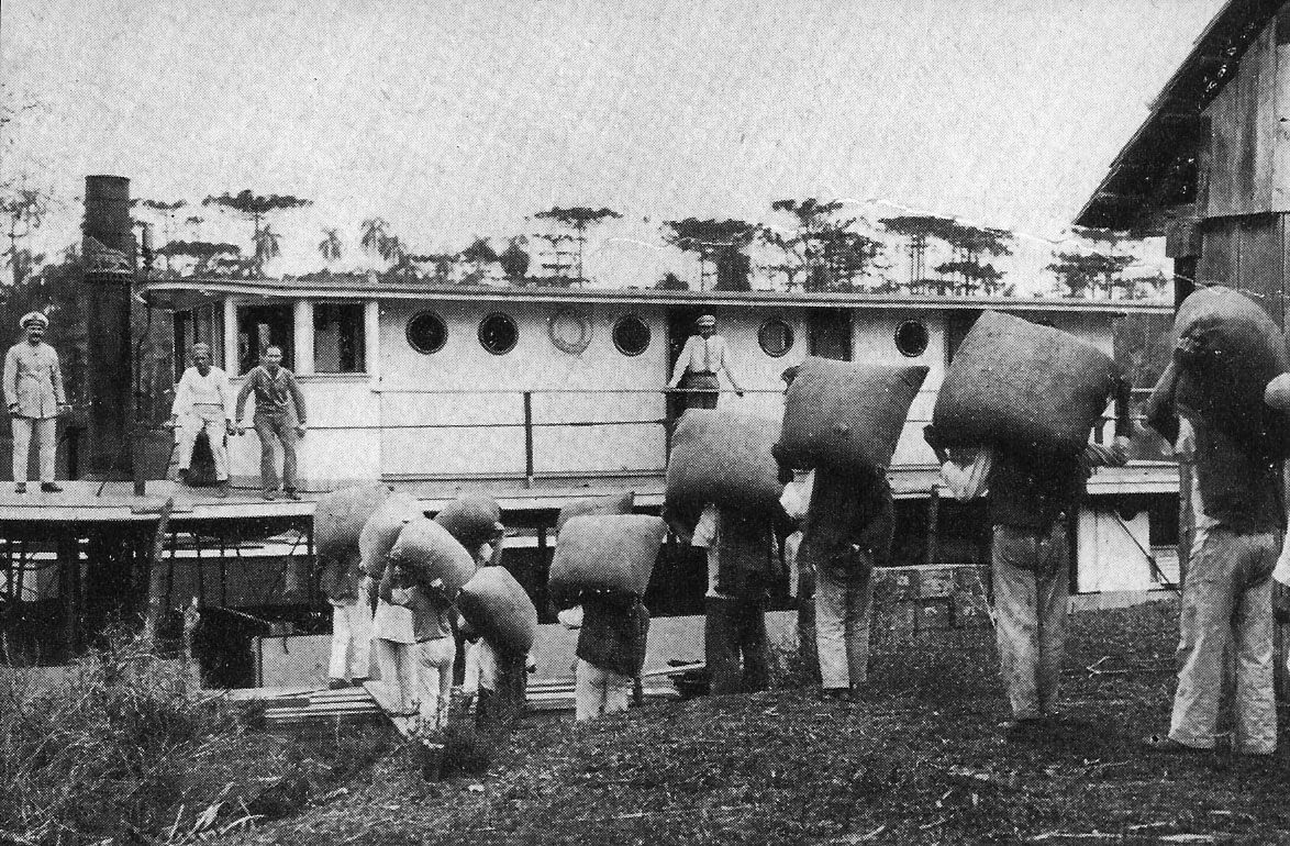 Uma imagem antiga de várias pessoas carregando erva-mate dentro de um vapor em são mateus do sul